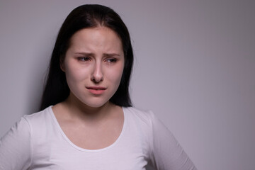  portrait of sad and depressed young woman. on gray background. nervous and upset people concept.