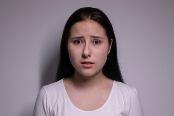  portrait of sad and depressed young woman. on gray background. nervous and upset people concept.