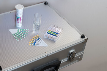 metal case with equipment for water analysis, ph and total water hardness test strips with a graduated water test tube