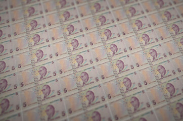 5 Turkish lira bills printed in illegal money production conveyor. Collage of many fake bills....