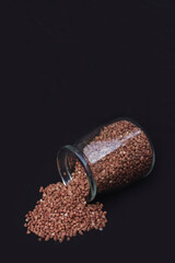 Buckwheat in a jar on a black background. Healthly food