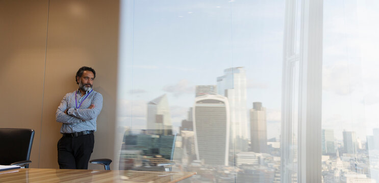 Thoughtful businessman in highrise urban conference room
