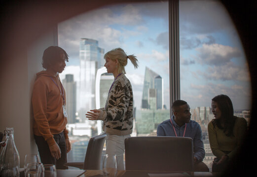 Business people talking in highrise conference room meeting