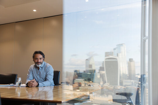 Portrait confident businessman in highrise conference room, London, UK