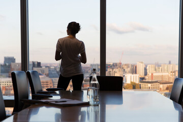 Thoughtful businesswoman looking out highrise office window