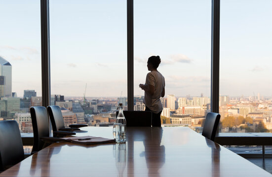 Thoughtful businesswoman at urban highrise office window