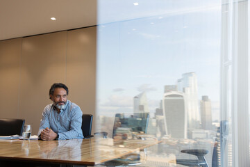 Thoughtful businessman in highrise conference room, London, UK