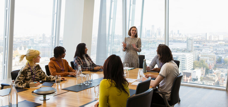Businesswoman leading conference room meeting in highrise office