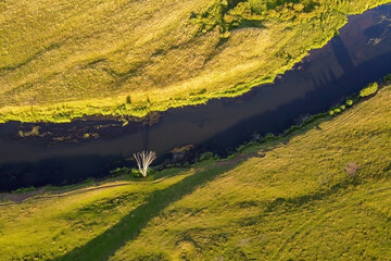 Aerial view of small river, green grass. Summer landscape, top view