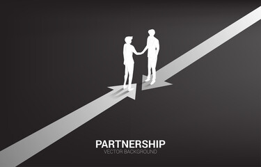 Fototapeta premium Silhouette of businessman handshake from opposite direction arrow. Concept of team work partnership and cooperation.