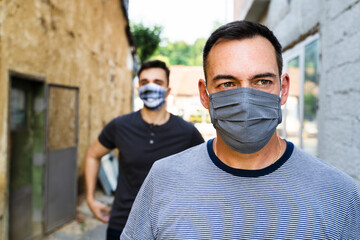 Caucasian adult man wearing protective mask walking in the city after lockdown reopening - Two men on the street maintain social distance due covid-19 pandemic spread during walk - New normal concept