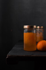 Preserved Tangerines with their juice in a glass jar, preserved citrus fruit