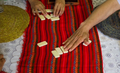 Hands of men picking dominoes tokens