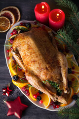 Whole roasted duck with oranges, berries and herbs. Christmas dinner meal table. Overhead, flat lay
