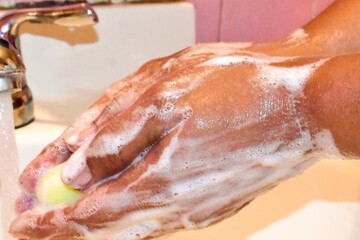 Woman Using Soap And Water To Wash Her Hands At The Sink