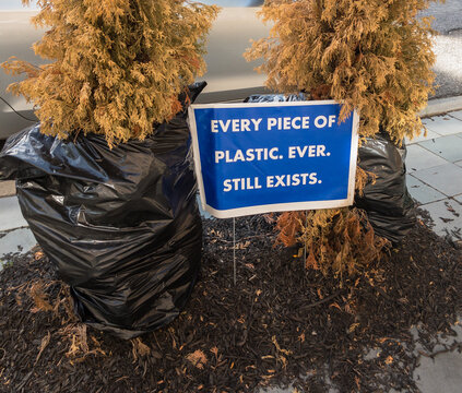 environmental sign: every piece of plastic ever still exists between plastic covered dead bushes