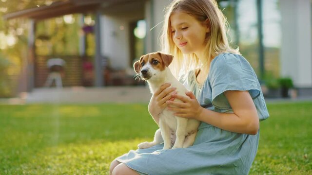 Cute Girl Holds Her Favorite Pedigree Dog Friend while Having Picnic Outdoors on the Lawn
