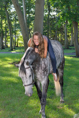 Adorable young girl rides her horse on a farm