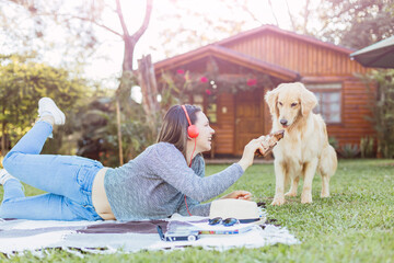 Beautiful woman listens to music with her dog.  She has fun playing with her pet.  She is in a country house.