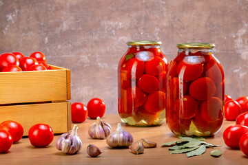 Fresh And Canned Tomatoes. Composition with pickled tomatoes in glass jars.