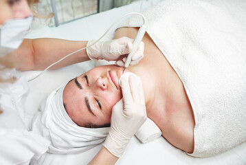 Fototapeta na wymiar Cosmetologist makes the procedure treatment of couperose Skin cleaning