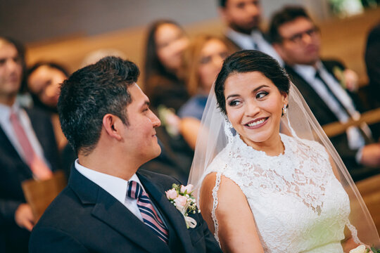 Latino bride and groom looking at each other during the ceremony