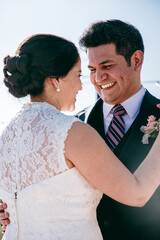 Latino bride and groom close up laughing and dancing