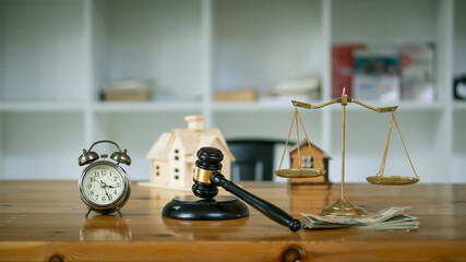 Golden scales and Law of Law hammer are placed on the table with objects, clocks and home designs in a vintage filter background in the office.
