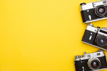 yellow background with three retro cameras, copy space