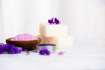 Fototapeta na wymiar Natural soap with aroma therapy and salt scrub for body and mind relaxation on white marble table with white background and copy space. Purple concept.