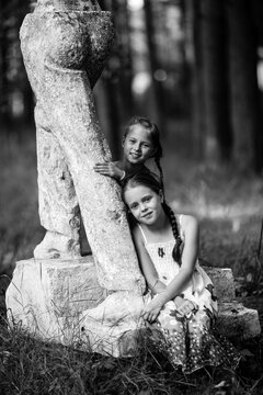Two little girls pose for a photo in the park. Black and white photography.