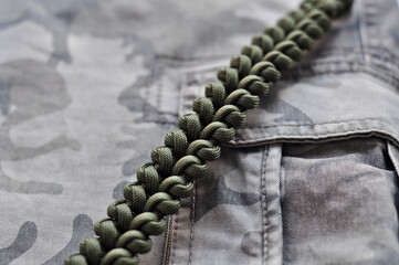 Braided bracelet from paracord color khaki military on hand with a lock knot in the form of a...