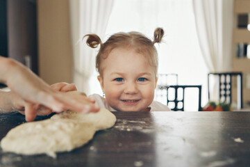 Fototapeta premium the baby makes cakes. the children were covered in flour. dinner at the bakery. feast in the kitchen
