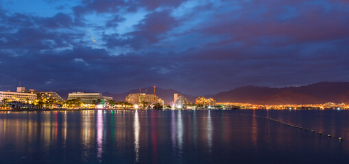 Fototapeta na wymiar Night panoramic view on the central public beach of Eilat - famous tourist resort and recreational city in Israel