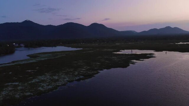 Moody fly over a Lake just after sunset. Mountains in the horizon.