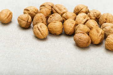 Heap of walnuts lie on natural cotton surface. Soft focus. Copyspace for text.