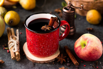 mulled wine in a red mug. hot spiced wine with cinnamon and star anise