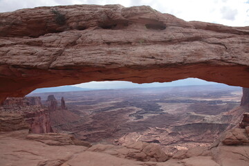 View of  Mesa Arch at island in the sky and landscape of Canyonlands National Park appearing under the arch in Utah, USA