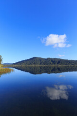 Calm mirror lake in the morning with mountain background in New Zealand.