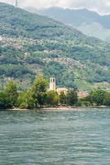 Fototapeta na wymiar Landscape with Catholic Church Santo Stefano in Dongo on Como Lake.
