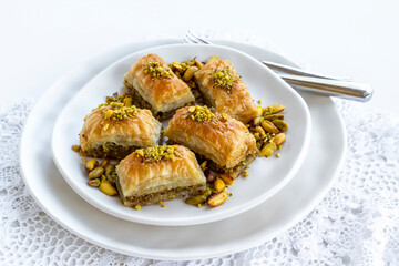 Traditional Turkish Pastry Dessert Baklava special designed on plate with pistachio nuts and cutlery set