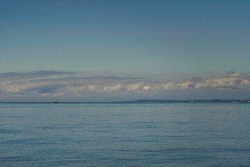 2020-09-01 THE PUGET SOUND OFF OF LUMI ISLAND WITH ONE TUG BOAT AND CLOUDS ON THE HORIZON