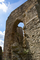 Ruin of an old medieval castle with a blue and cloudy sky in background