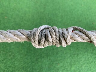 A rope knot on the green grass background