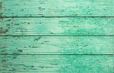 Background from wooden old boards with cracked paint. Vintage green fence texture as abstract background.
