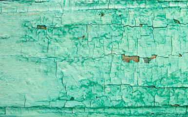 Background from wooden old boards with cracked paint. Vintage green fence texture as abstract background.