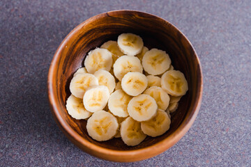 simple food ingredients, sliced banana in wooden bowl as healthy snack