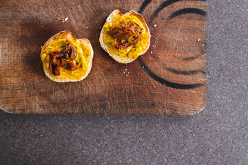 simple food ingredients, bread slices with sweet potoato and kale dip topped with sundried tomatoes
