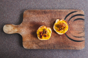 simple food ingredients, bread slices with sweet potoato and kale dip topped with sundried tomatoes
