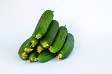 Fresh cucumbers heap on white surface with copy space